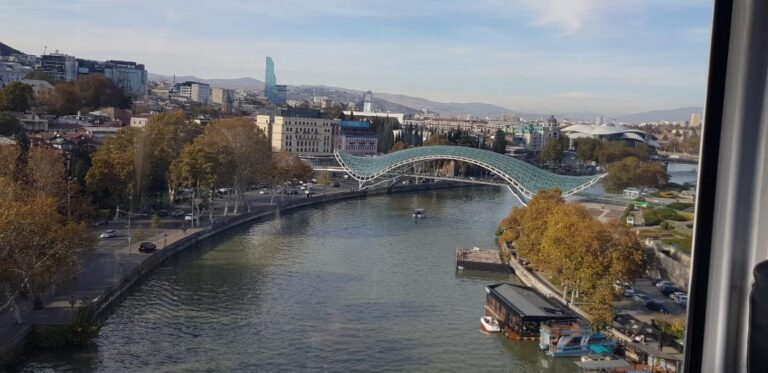 A view of the Kura River and the Bridge of Peace from the cable car. Georgia, the mystical transcontinental nation