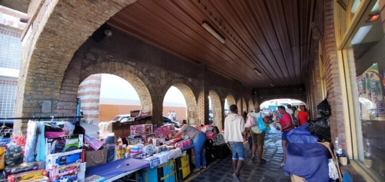 Vendors selling under buildings with arches. St. Vincent and the Grenadines the Gem of the Antilles